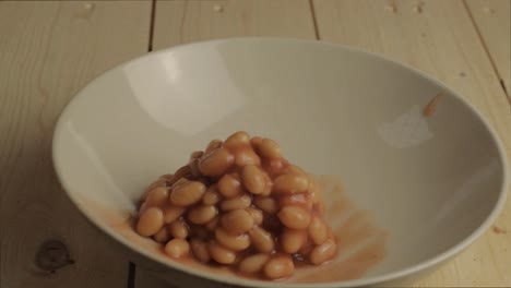 Baked-beans-in-tomato-sauce-pouring-into-a-bowl