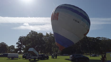 Hot-air-balloon-crew-erecting-inflating-their-balloon-ready-for-a-tethered-display-at-a-hot-air-balloon-festival