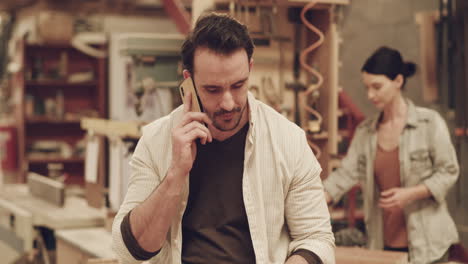 a-handsome-young-carpenter-making-a-phone-call