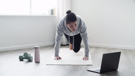 a-young-woman-using-a-laptop-while-working-out