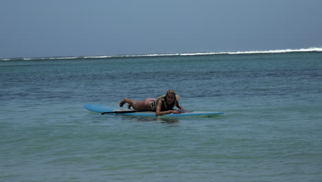 Pretty-young-girl-lying-Alone-on-paddle-board-on-indian-ocean-in-summer