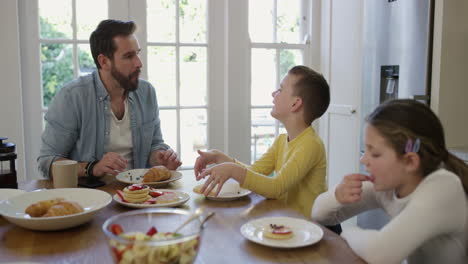 a-man-and-his-two-kids-having-breakfast-at-home