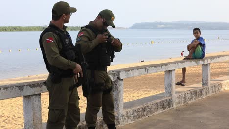 Bewaffnete-Lateinamerikanische-Militärpolizisten-Stehen-Wache,-Während-Sie-Einen-Strand-überwachen