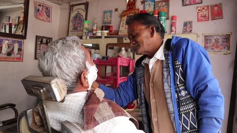 Indian-Barber-Applied-Shaving-Foam-By-A-Swab-To-The-Face-Of-An-Old-Man,-Man-Doing-Shaving-In-Barber-Shop