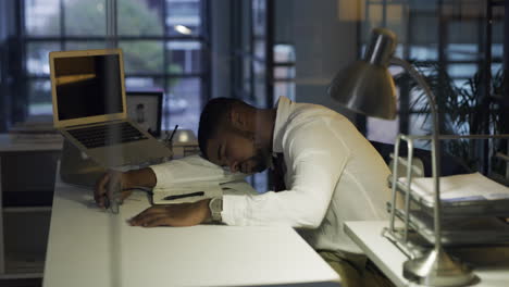 young-businessman-sleeping-at-his-desk-during