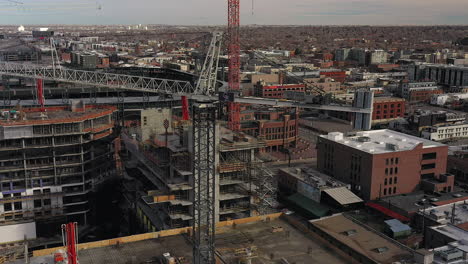 Aerial-Drone-footage-of-construction-cranes-and-Coors-field-in-Downtown-Denver,-Colorado