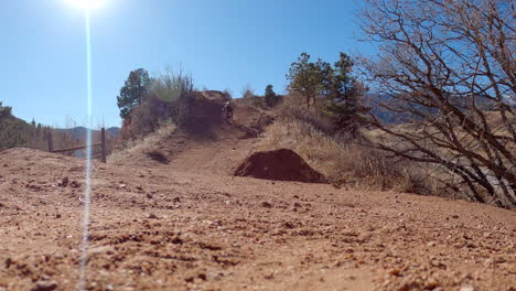 Young-man-on-mountain-bike-jumping-dirt-hills-on-an-obstacle-course,-in-Colorado-Springs,-Colorado