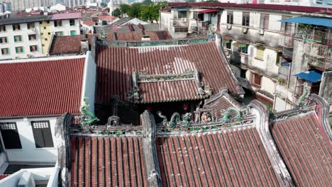 Roof-view-of-Kew-Leong-Tong-Lim-Kongsi-clan-temple-in-Lebuh-street,-drone-fly-out-reveal-shot