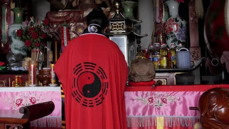 A-Taoist-female-monk-in-Weibaoshan,-China-arranging-the-altar-for-worship---Wide-shot