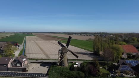 Flying-with-a-drone-over-a-spinning-Dutch-windmill-with-sails-on-the-fencing-of-the-blades