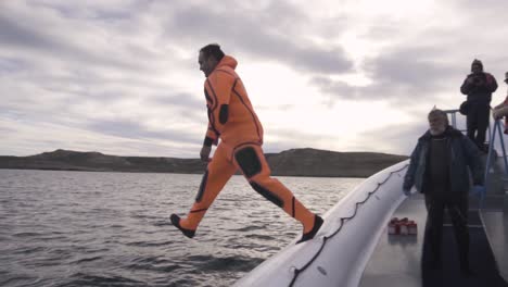 A-Man-Wearing-Orange-Immersion-Suit-Jumps-To-The-Water-As-Part-Of-The-Nautical-Training-In-Patagonian-Sea---Slowmo