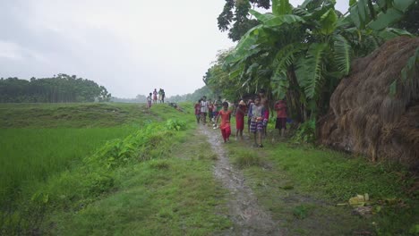 Poor-rural-children-having-fun-and-running-towards-home-in-rain-in-village,-slow-motion