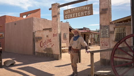 A-Cowboy-Actor-Posing-At-The-Entrance-Of-Old-Tombstone-Gunfights-In-Tombstone,-Arizona-On-A-Bright-Weather---Slowmo