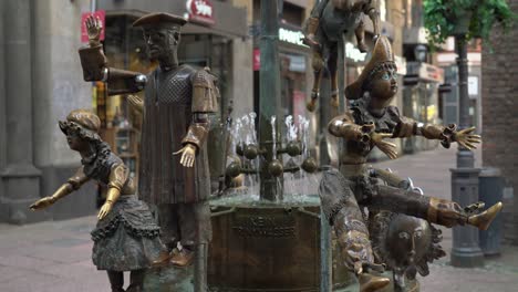 The-Dolls-Fountain-in-the-pedestrian-area-Krämerstraße-in-the-City-of-Aachen,-next-to-the-cathedral