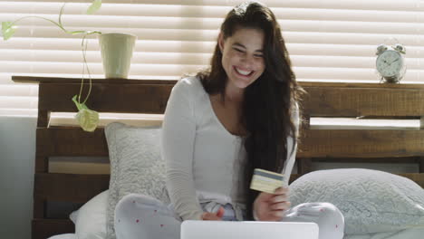 a-woman-holding-her-credit-card-while-using