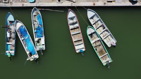 Luftaufnahme-Mit-Direktem-Blick-Nach-Unten-Und-Nach-Rechts-Gleitender-Kamera,-Die-Kleine-Hölzerne-Fischerboote-In-Einem-Hafen-In-Mexiko-Zeigt