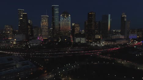 This-video-is-about-an-aerial-view-of-downtown-Houston-at-night-with-traffic-going-pass-downtown