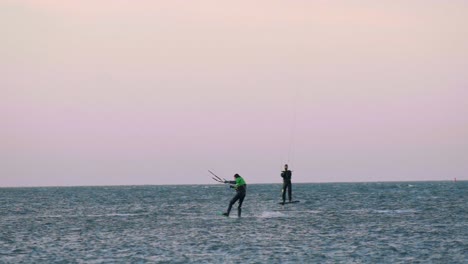 Adults-Kite-Surfing-In-Waters-Off-Dutch-Wadden-Islands-Against-Pink-Skies