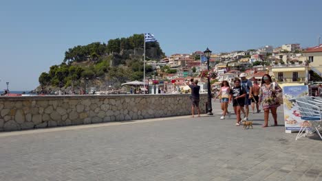 People-walking-during-the-morning-hours-in-Parga,-Greece-on-a-sunny-day