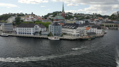 Schnellboote-Segeln-Und-Hinterlassen-Eine-Spur-An-Der-Norwegischen-Küste-In-Der-Nähe-Des-Pollenhafens,-Des-Clarion-Hotels-Und-Der-Trinity-Church-In-Tyholmen,-Arendal,-Norwegen