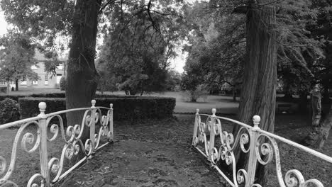 POV-walking-on-a-white-garden-bridge-in-black-and-white