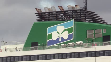 Irish-Ferries-close-up-decks-with-an-Irish-shamrock-on-the-engine-and-with-people-upper-deck-and-person-waling-by