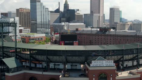 Descending-aerial,-Oriole-Park-at-Camden-Yards,-Baltimore-skyline,-MLB-Professional-Baseball-field,-Pandora,-Transamerica,-PNC-logos