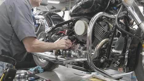 Mechanic-student-tuning-a-motorcycle-in-a-trade-school-repair-shop-program-slider-shot