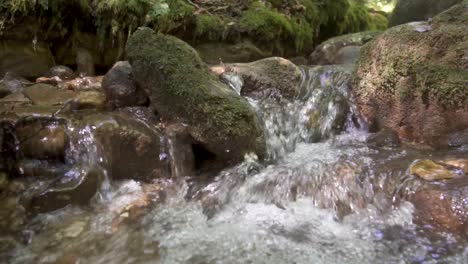 Fließendes-Reines-Wasser-Eines-Natürlichen-Baches,-Der-Die-Bergfelsen-Hinunterfließt