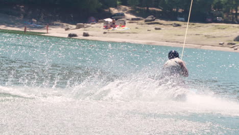A-Man-Kneeboarding-In-The-Calm-Blue-Lake-On-A-Hot-Summer-Day---panning-shot