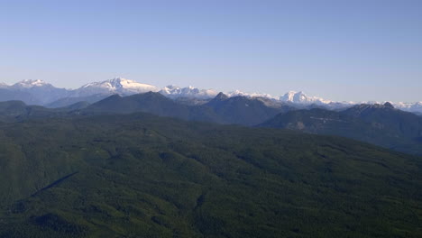 Lush-And-Rocky-Mountains-Covered-With-Snow---Beautiful-Landscape-Over-Sunshine-Coast-In-British-Columbia,-Canada---wide-aerial-shot
