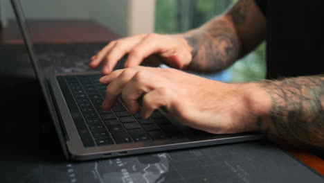 Closeup-of-a-man-writing-on-a-laptop
