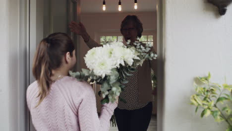 a-young-woman-surprising-her-grandmother-with-some