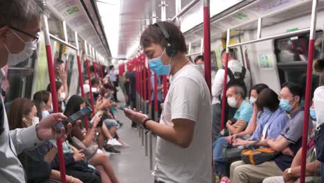 Commuters-using-face-masks-as-a-prevention-against-Coronavirus,-officially-known-as-Covid-19,-are-seen-riding-MTR-subway-train-in-Hong-Kong