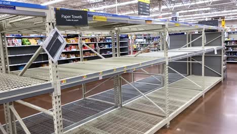 Pan-view-of-empty-paper-towel-shelves-at-Walmart,-Covid-19-Coronavirus-of-hoarding-customers
