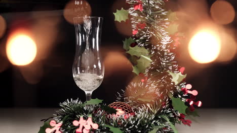 Gießen-Sie-Champagner-In-Eine-Flöte-Mit-Weihnachtsgirlandendekoration-Und-Wunderkerzen,-Feuerwerkslichtern