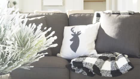 Holiday-decorated-living-room-space-with-winter-pillows-and-decorations