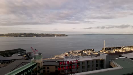 Cloudy-morning-over-Pikes-Place-Market-and-the-waterfront-along-Elliot-Bay,-aerial-zoom-out
