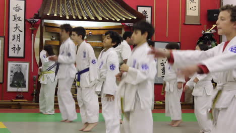 Karate-Teacher-Helps-Students-in-Class-Warm-Up,-Jumping-Up-and-Down