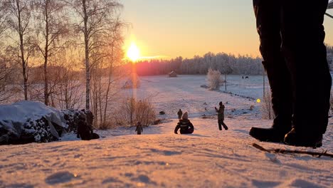 Multiple-Winter-activities-in-Scandinavia,-Group-of-people-snow-tubing-down-a-slope-in-beautiful-winter-weather