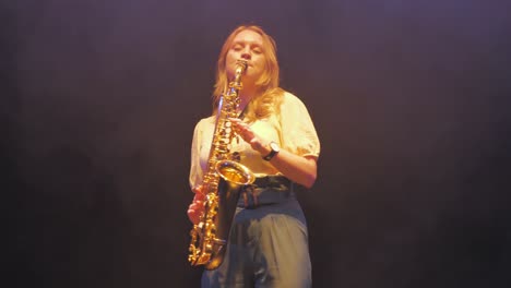 Young-Woman-Playing-Music-on-Saxophone-Under-Stage-Lights
