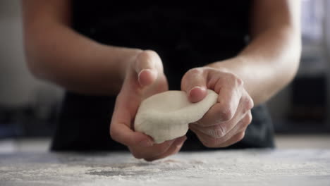an-unrecognizable-woman-kneading-dough-at-home