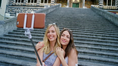 Two-happy-friends-taking-selfies-with-a-smartphone