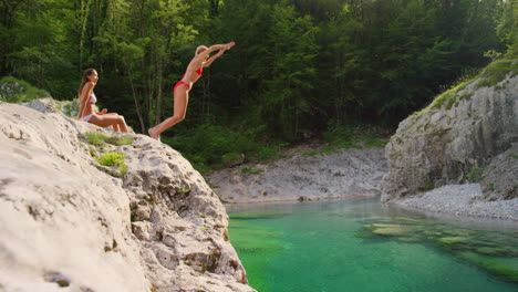 Excited-young-woman-jumping-into-a-lake
