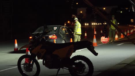 Military-Deployed-At-State-Border-Checkpoint-Due-To-Pandemic-Restrictions---Police-In-Reflectorized-Jacket-Talking-To-A-Driver-Of-Black-Car-At-Night-In-Australia
