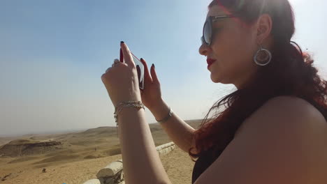 Die-Kamera-Dreht-Sich-Um-Ein-Mädchen,-Das-Den-Pyramidenkomplex-Von-Gizeh-Fotografiert-Und-Dann-Rückwärts-Geht,-Um-Die-Wunderschöne-Landschaft-An-Einem-Sonnigen-Tag-In-Ägypten-Zu-Offenbaren
