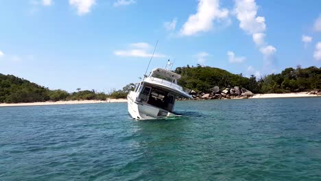 Ship-wreck-crashed-in-shallow-tropical-waters-with-island-in-background