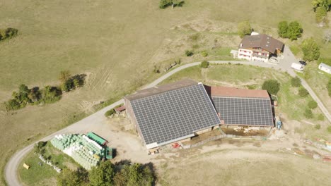 Aerial-slow-orbit-above-farm-with-roof-covered-with-solar-panels-Near-Mont-Pèlerin,-Vaud---Switzerland