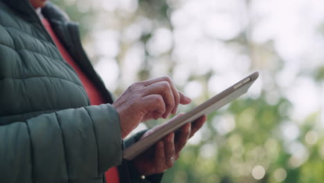 Senior-hands-browsing-finance-on-tablet