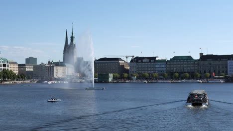 View-at-Binnenalster-Lake-in-Hamburg-at-sunny-day-with-tourist-ship-driving-through-the-scene
